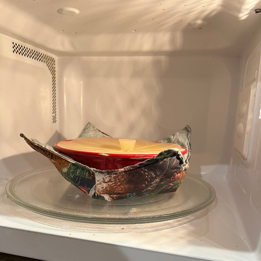 Ceramic bowl in a cozy placed inside of a microwave.